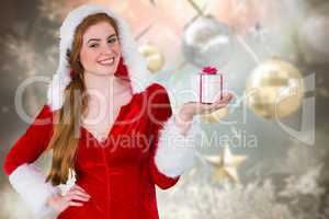 Composite image of pretty girl in santa costume holding gift box