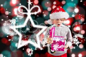 Composite image of festive boy holding a gift