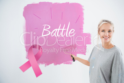 Composite image of happy young woman painting her wall pink