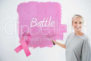 Composite image of happy young woman painting her wall pink