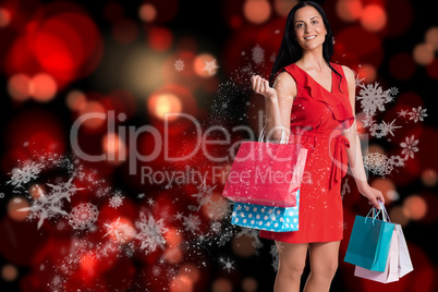 Composite image of woman standing with shopping bags