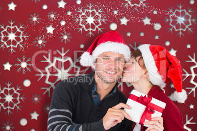 Composite image of couple holding a christmas gift Composite image of couple holding a christmas gift