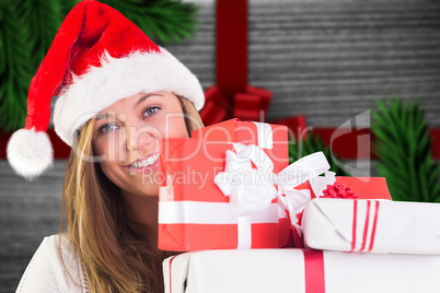 Composite image of festive blonde holding pile of gifts Composite image of festive blonde holding pile of gifts