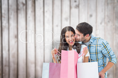 Composite image of happy couple with shopping bags