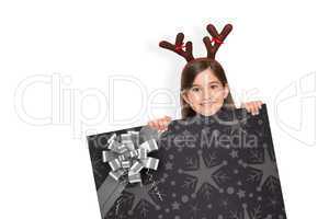 Composite image of festive little girl showing card