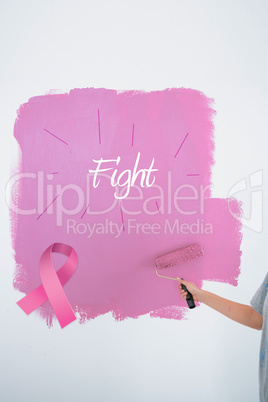 Composite image of woman painting her wall pink