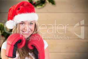 Composite image of festive blonde with boxing gloves