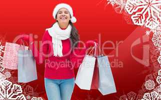 Composite image of festive brunette holding shopping bags