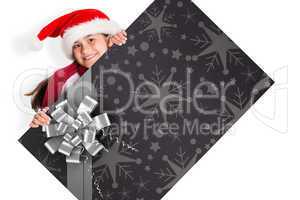 Composite image of festive little girl showing card