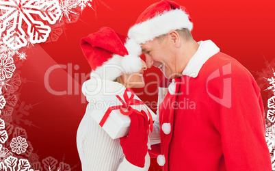 Composite image of festive mature couple holding gift