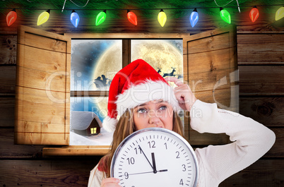 Composite image of festive blonde showing a clock
