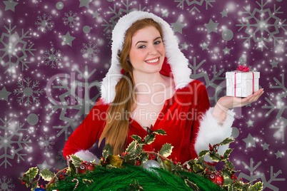 Composite image of pretty girl in santa costume holding gift box