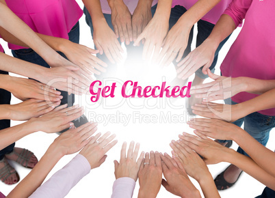 Hands joined in circle wearing pink for breast cancer