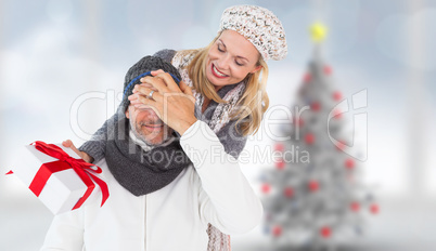 Composite image of happy winter couple with gift