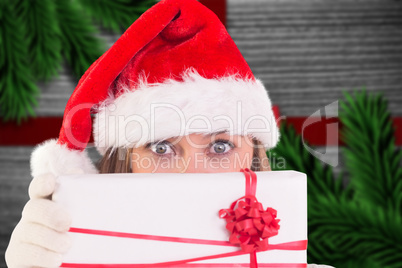 Composite image of festive blonde holding a gift