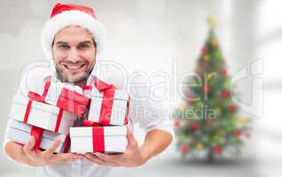 Composite image of festive man holding christmas gifts