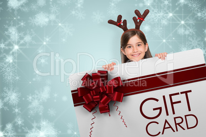 Composite image of festive little girl showing card