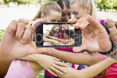 Composite image of hand holding smartphone showing