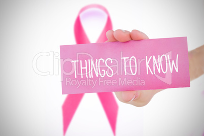 Composite image of young woman holding pink card