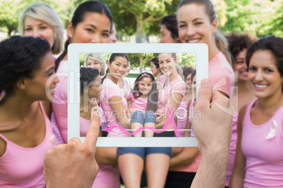 Composite image of hand holding tablet pc