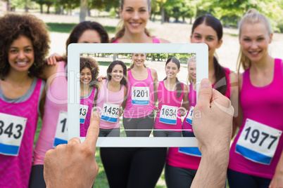 Composite image of hand holding tablet pc