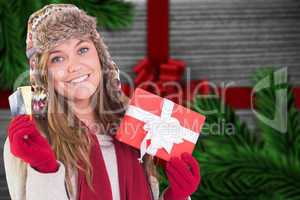 Composite image of happy blonde in winter clothes holding gifts