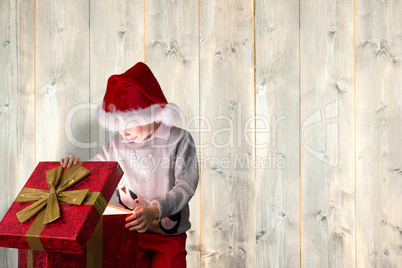 Composite image of festive boy opening gift