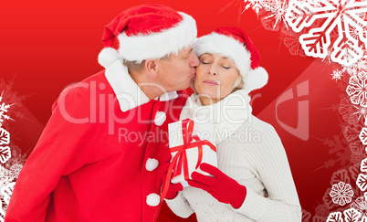 Composite image of festive mature couple holding gift