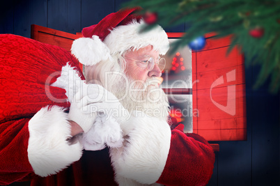 Composite image of santa claus carrying sack