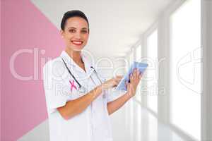 Composite image of pretty nurse using tablet pc