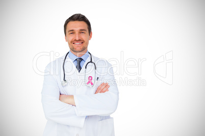 Composite image of handsome young doctor with arms crossed