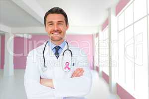 Composite image of handsome young doctor with arms crossed