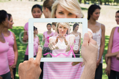 Composite image of hand holding tablet pc