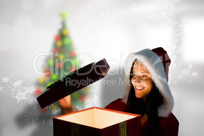 Composite image of smiling woman opening christmas present