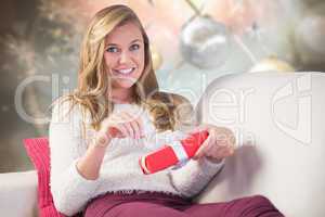 Composite image of pretty blonde opening a gift