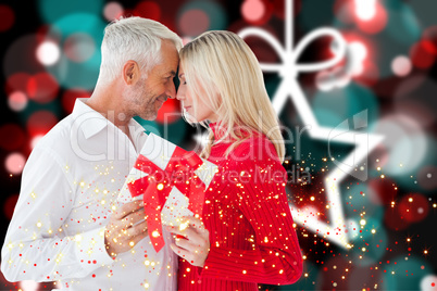 Composite image of loving couple with gift