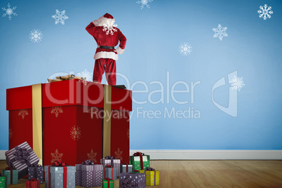 Composite image of santa standing on giant present