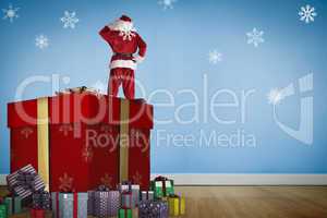 Composite image of santa standing on giant present