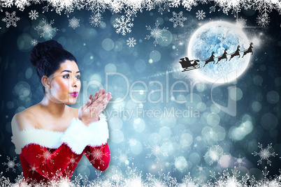 Composite image of pretty santa girl blowing over her hands