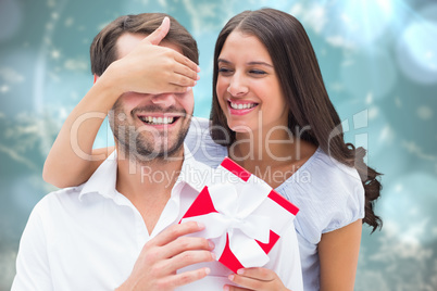 Composite image of woman surprising boyfriend with gift