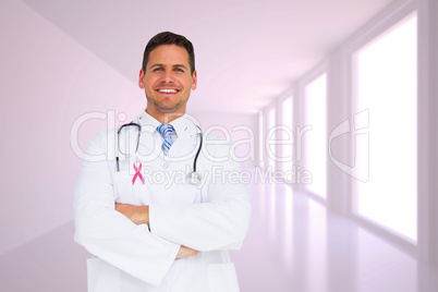 Composite image of handsome doctor with arms crossed