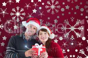 Composite image of couple holding a christmas gift