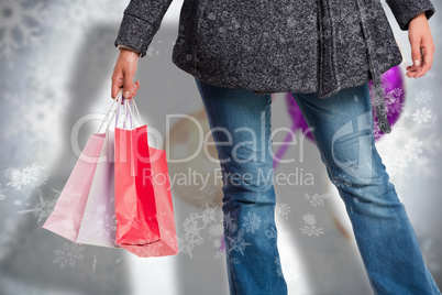 Composite image of smiling woman holding shopping bag