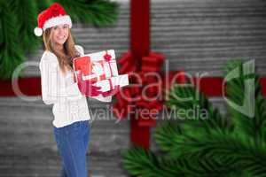 Composite image of festive blonde holding pile of gifts