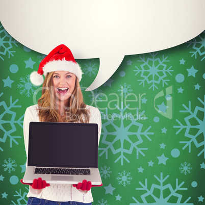 Composite image of festive blonde showing a laptop