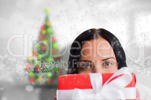 Composite image of woman holding a present