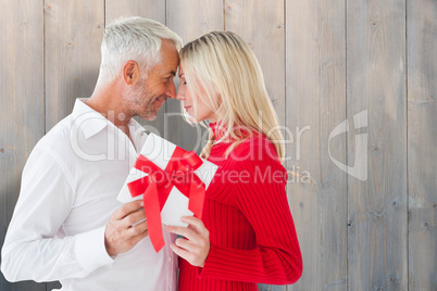 Composite image of loving couple with gift