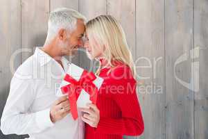 Composite image of loving couple with gift