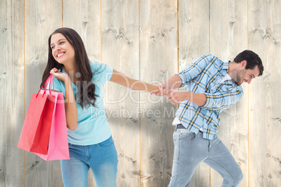 Composite image of happy couple with shopping bag