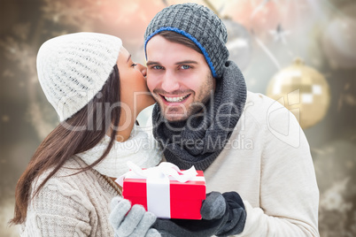 Composite image of winter couple holding gift